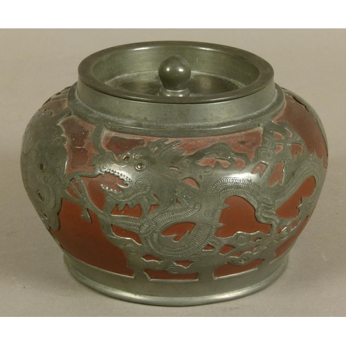 105 - A CHINESE WHITE METAL MOUNTED TERRACOTTA TOBACCO JAR, the mount pierced and engraved with stylised d... 