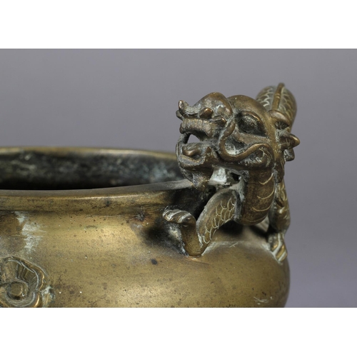 106 - A CHINESE BRONZE TWO HANDLED CENSER of compressed cauldron form, the handles formed as sinuous drago... 