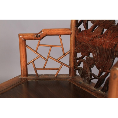 107 - A CHINESE ELM ELBOW CHAIR, the arched back with panelled top carved with fan shaped panel of figure ... 