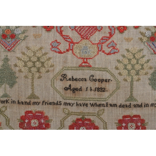 11 - AN EARLY 19TH CENTURY SAMPLER worked by Rebecca Cooper aged 11, 1832, with text, flowering trees and... 