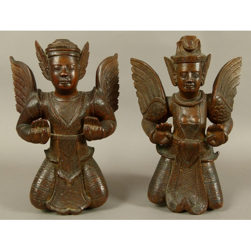 124 - A PAIR OF BURMESE/THAI CARVED HARDWOOD MALE AND FEMALE DEITY, late 19th/early 20th century, the wing... 