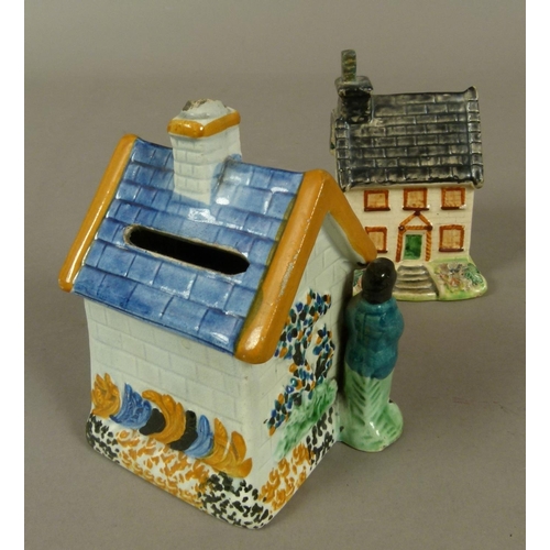 143 - A 19TH CENTURY STAFFORDSHIRE PRATTWARE COTTAGE MONEY BOX of typical architecture flanked by a husban... 