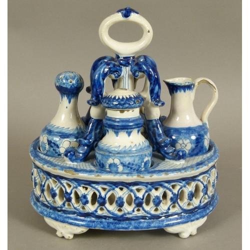 147 - A 19TH CENTURY CONTINENTAL POTTERY CRUET STAND of oval form, decorated in underglaze blue, the stand... 