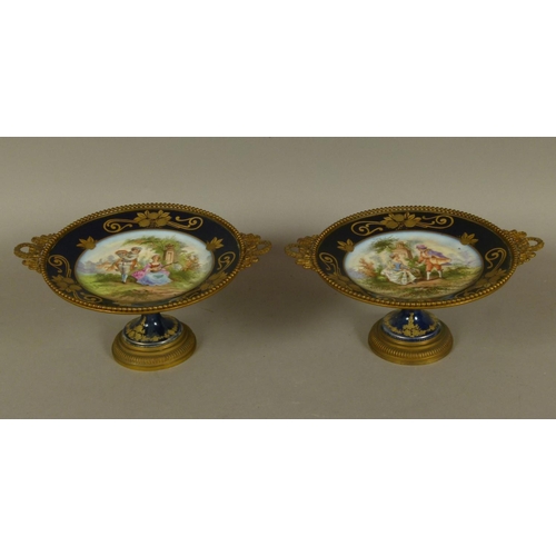 150 - A PAIR OF LATE 19TH CENTURY FRENCH PORCELAIN AND GILT BRONZE MOUNTED TAZZAE, circular painted to the... 