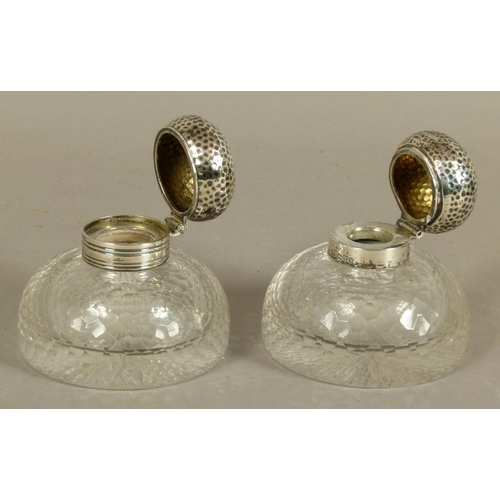 200 - A PAIR OF GEORGE V SILVER LIDDED GLASS INKWELLS of domed circular form with honeycomb faceted decora... 