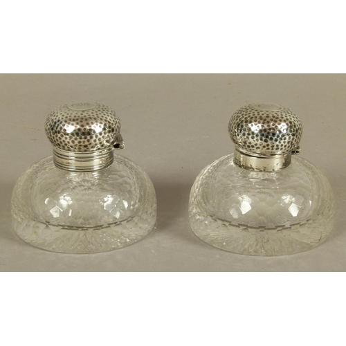 200 - A PAIR OF GEORGE V SILVER LIDDED GLASS INKWELLS of domed circular form with honeycomb faceted decora... 