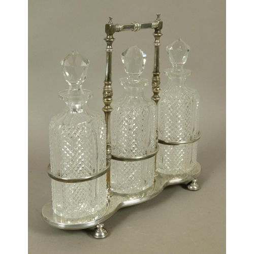 218 - A LATE VICTORIAN/EDWARD VII SILVER PLATED TRIPLE DECANTER STAND and three diamond cut glass decanter... 