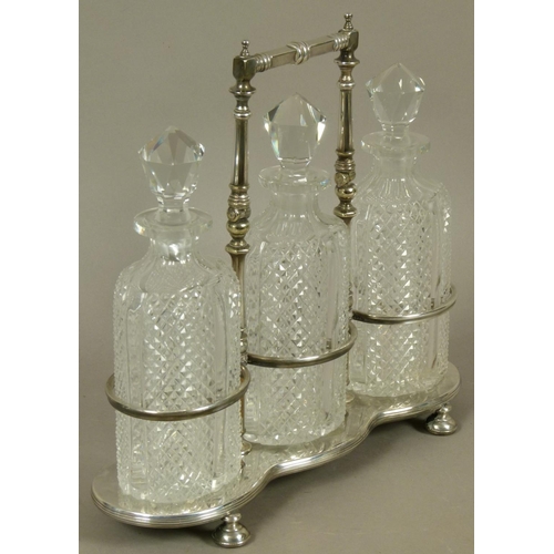 218 - A LATE VICTORIAN/EDWARD VII SILVER PLATED TRIPLE DECANTER STAND and three diamond cut glass decanter... 