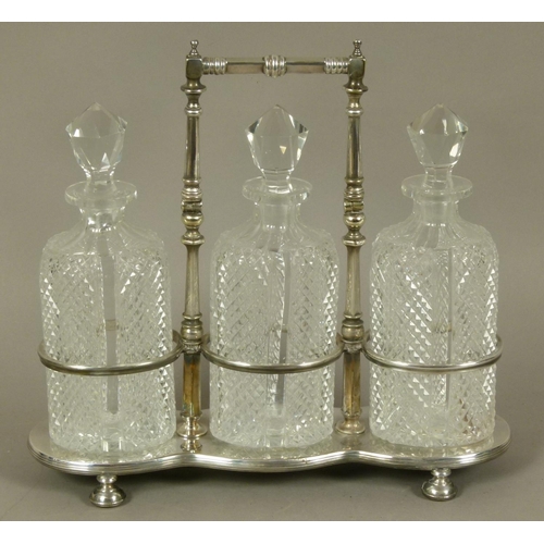 218 - A LATE VICTORIAN/EDWARD VII SILVER PLATED TRIPLE DECANTER STAND and three diamond cut glass decanter... 