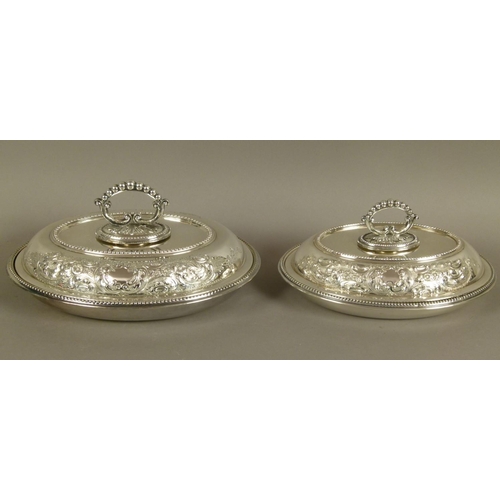 219B - A PAIR OF EARLY 20TH CENTURY SILVER PLATED OVAL TUREENS AND COVERS, with detachable beaded loop hand... 