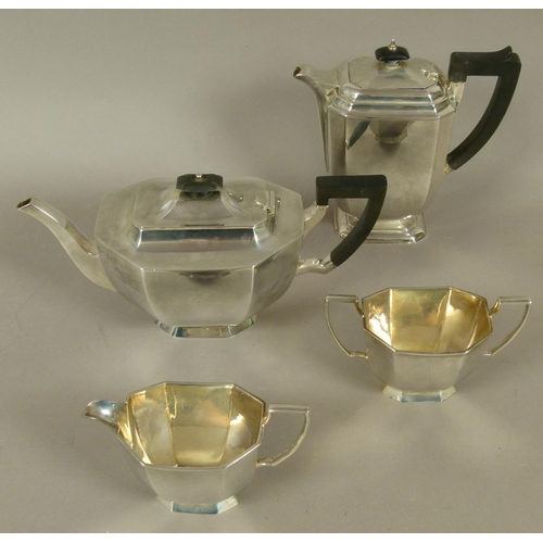 277 - A GEORGE V SILVER FOUR PIECE TEA SERVICE of irregular octagonal form, with ebonised finials and angu... 