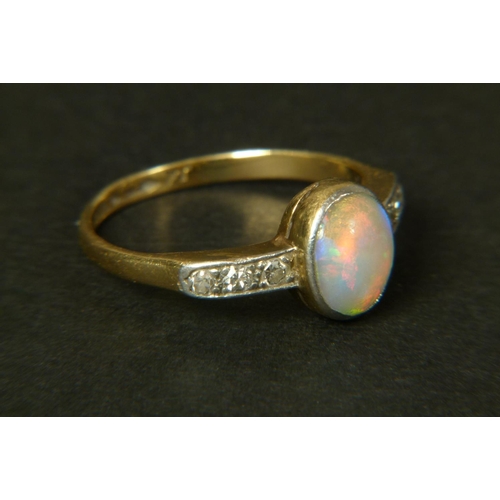 320 - AN OPAL AND DIAMOND RING, c.1950 in 18ct gold and platinum, the oval opal cabochon collet set to the... 