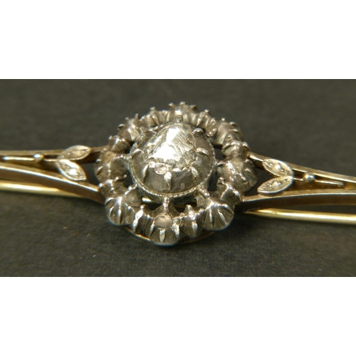 338 - A DIAMOND BAR BROOCH, set to the centre with a foil backed rose cut stone in a cut down setting with... 