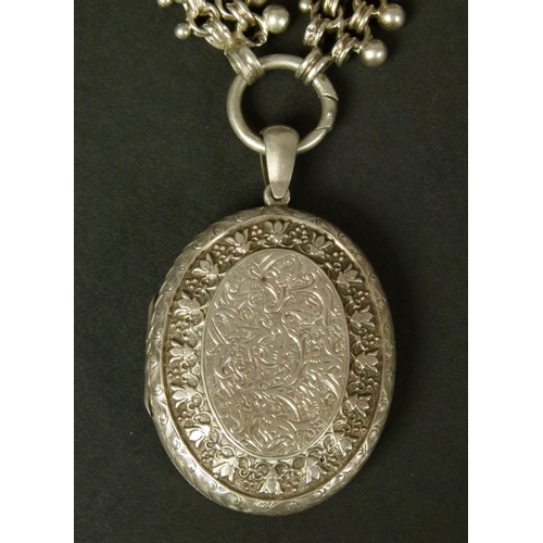 352 - A VICTORIAN SILVER LOCKET AND COLLAR, the oval locket foliate engraved and hung from a double reeded... 