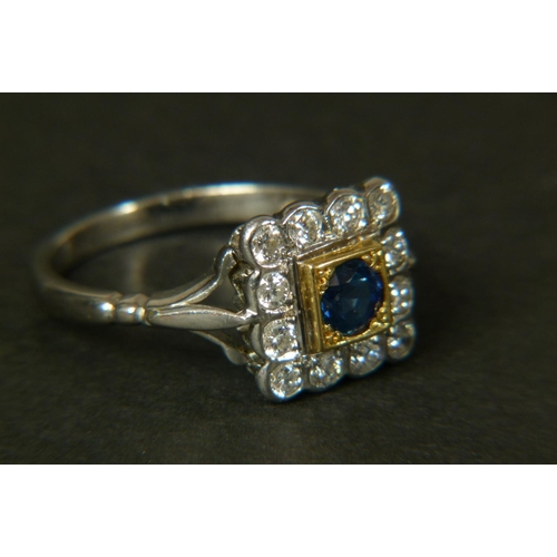 358 - A SAPPHIRE AND DIAMOND CLUSTER RING, in 18ct yellow and white gold, the circular faceted sapphire se... 