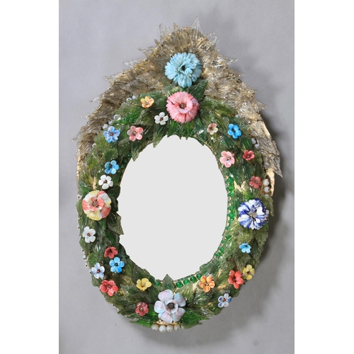 482 - AN ORNATE VENETIAN OVAL WALL MIRROR, the convex moulded ground applied with coloured glass flowers a... 