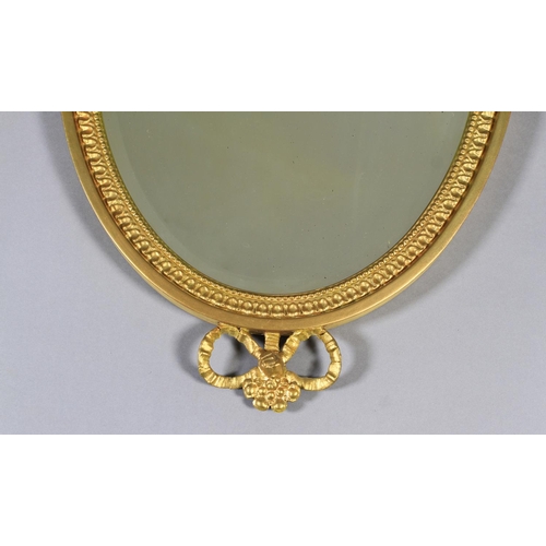 484 - A PAIR OF EDWARD VII GILT WALL MIRRORS the oval bevelled plate within a beaded frame with urn and ri... 