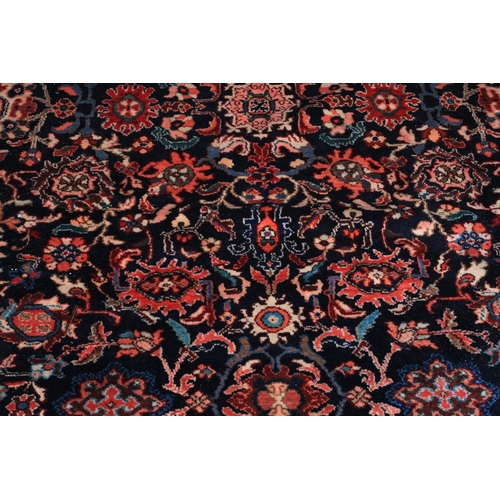 493 - A PERSIAN CARPET, Nenej Southern Hamadam Region the dark blue ground filled with plant forms in rose... 