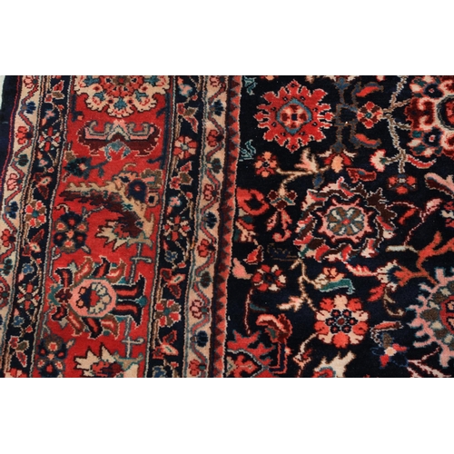 493 - A PERSIAN CARPET, Nenej Southern Hamadam Region the dark blue ground filled with plant forms in rose... 