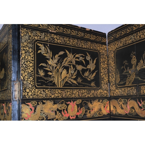 506 - A CHINESE EIGHT FOLD BLACK LACQUER AND GILT DECORATED SCREEN, the central continuous panel with land... 