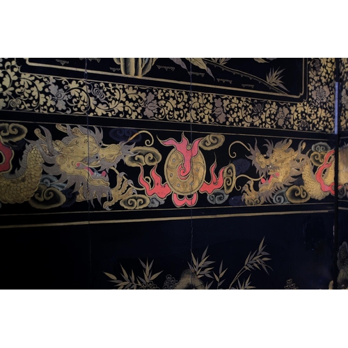 506 - A CHINESE EIGHT FOLD BLACK LACQUER AND GILT DECORATED SCREEN, the central continuous panel with land... 