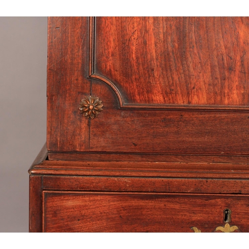 512 - A GEORGE III MAHOGANY CLOTHES PRESS the concave cornice having dentil moulding, above two figured do... 