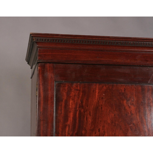 525 - A GEORGE III MAHOGANY CLOTHES PRESS with dental moulded cornice, above a pair of doors, four interio... 