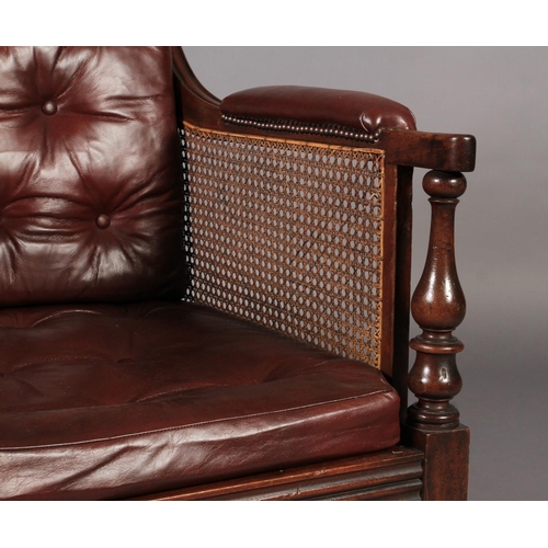 533 - A POST REGENCY MAHOGANY FRAMED LIBRARY BERGERE ARM CHAIR having a moulded frame, baluster turned arm... 