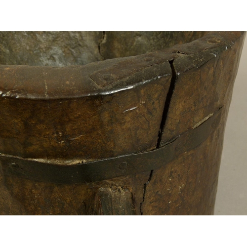 558 - AN 18TH CENTURY TWO HANDLED WOODEN MORTAR of chip-carved cylindrical trunk form with angular handles... 