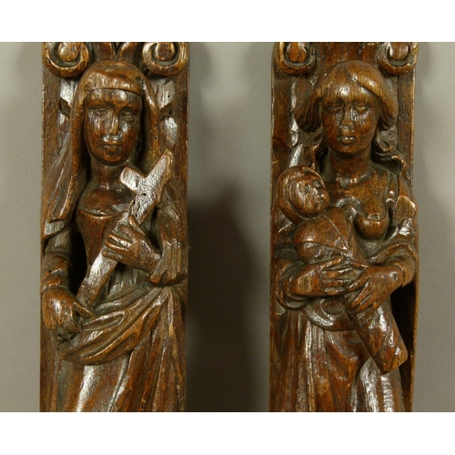 561 - A PAIR OF 17TH CENTURY FIGURAL CARVINGS one with female figure carrying a swaddled infant, the other... 