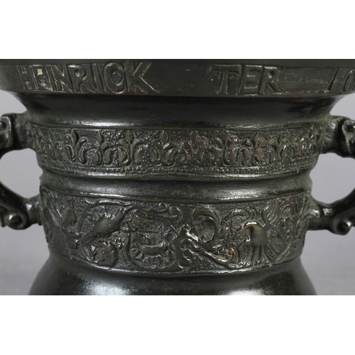 565 - A 17TH CENTURY DUTCH BRONZE PESTLE AND MORTAR of flared cylindrical form, the upper rim inscribed: H... 