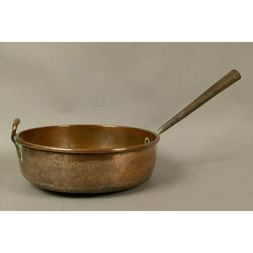 571 - A LARGE COPPER PAN 19th century, circular, having a tapering hollow iron handle and copper loop hand... 