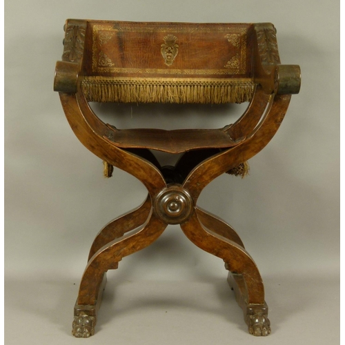 577 - A 17TH CENTURY CONTINENTAL WALNUT FOLDING X-FRAME CHAIR with acanthus carved slab arms terminating i... 