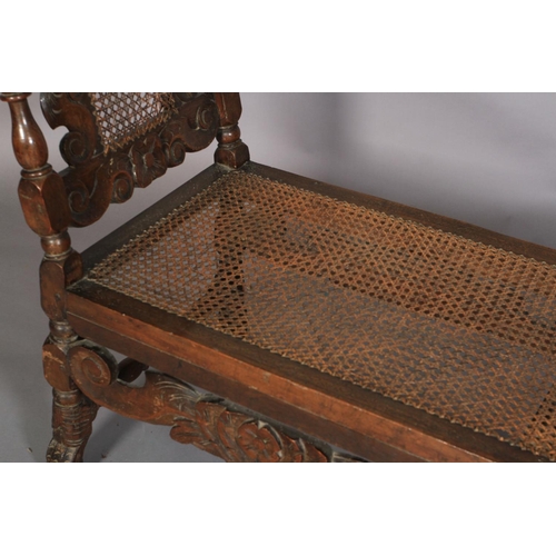 581 - A CHARLES II BEECHWOOD DAY BED, the bergere caned end panel within a foliate carved frame with turne... 