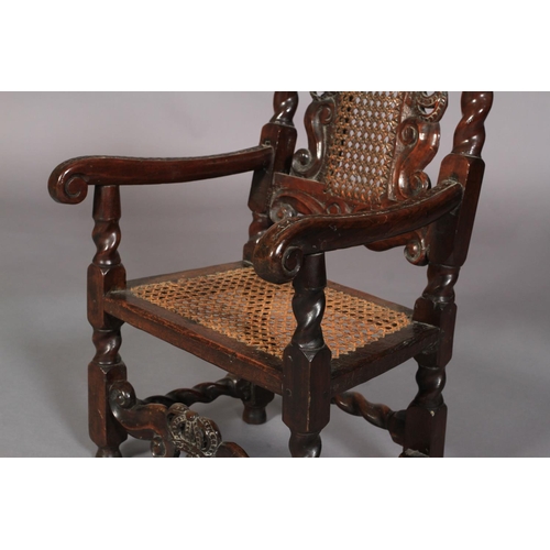 585 - A CHILD'S WALNUT ARMCHAIR OF CHARLES II STYLE, stamped T.C. beneath the arm, having a pierced and ca... 