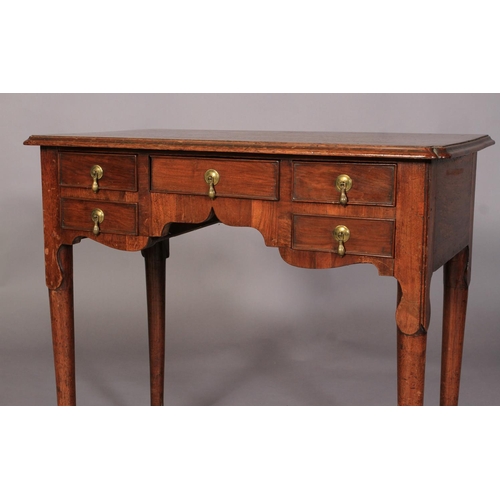 600 - A GEORGE II STYLE WALNUT SIDE TABLE, the rectangular top with re-entrant front corners above one cen... 