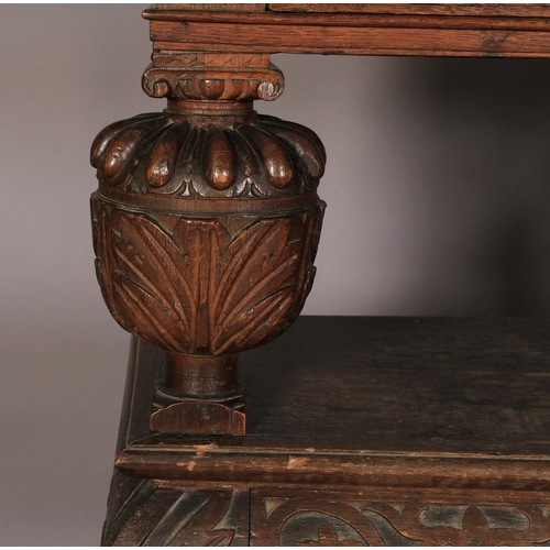 601 - AN OAK THREE TIER BUFFET in mid 16th century style, the top above foliate carved frieze drawer, the ... 