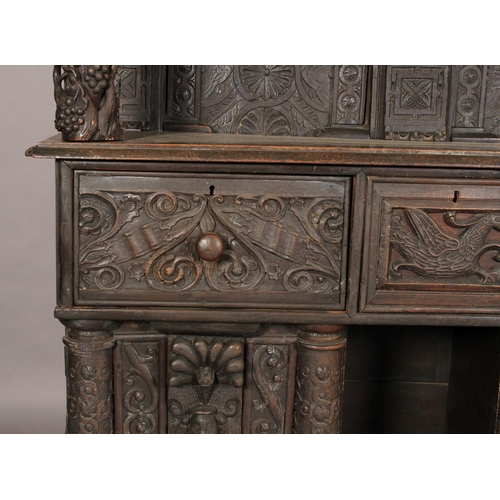 602 - AN OAK DRESSER/CUPBOARD in 16th century style, dentil moulded cornice above a frieze centred on a gr... 