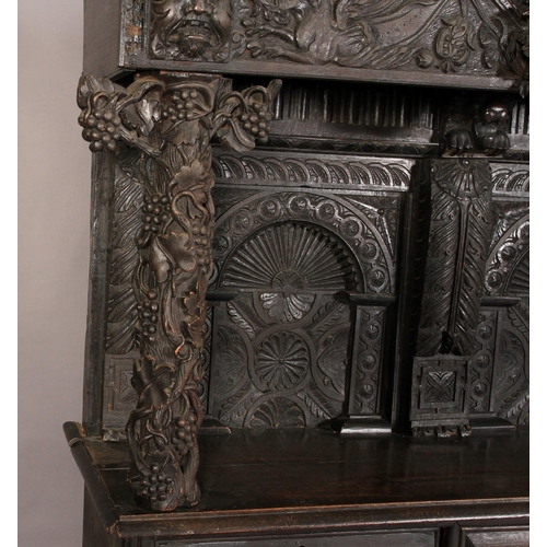 602 - AN OAK DRESSER/CUPBOARD in 16th century style, dentil moulded cornice above a frieze centred on a gr... 