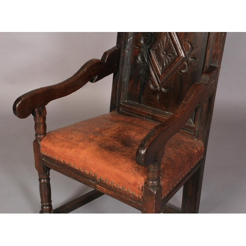 609 - AN OAK ARMCHAIR in 17th century style, the carved top rail above a lozenge carved panel back, slab a... 