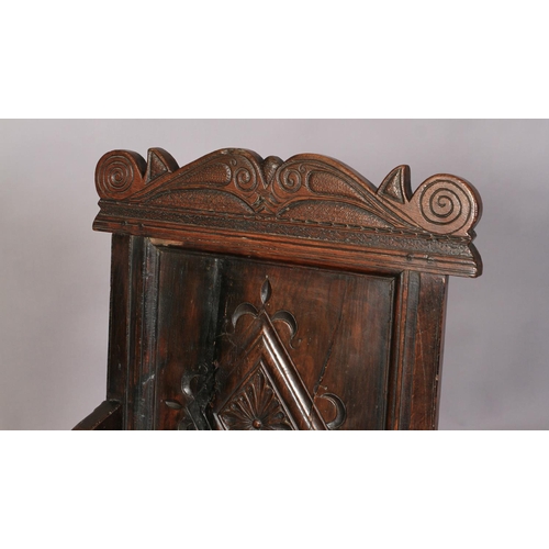 609 - AN OAK ARMCHAIR in 17th century style, the carved top rail above a lozenge carved panel back, slab a... 