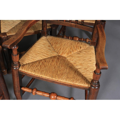 612 - A SET OF TEN ELM SPINDLE BACK RUSH SEATED DINING CHAIRS, early 19th century, on rounded legs and tur... 