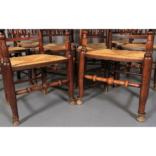 612 - A SET OF TEN ELM SPINDLE BACK RUSH SEATED DINING CHAIRS, early 19th century, on rounded legs and tur... 