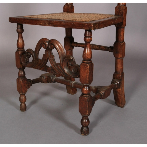 614 - A WILLIAM AND MARY WALNUT AND BEECH HIGH BACK CHAIR with pierced scroll carved cresting rail above a... 