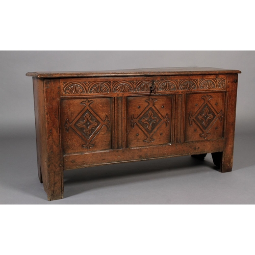 617 - A LATE 17TH CENTURY OAK KIST the hinged single plank top with moulded lip above a lunettes carved fr... 