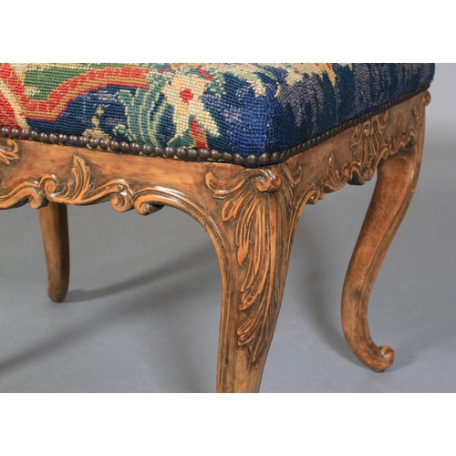 622 - A REGENCY STYLE STOOL IN WALNUT AND BEECH, rectangular, having a needlework upholstered seat, shell ... 