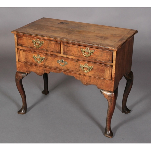 624 - A GEORGE I WALNUT CROSSBANDED SIDE TABLE having two short and one long drawer, crossbanded and with ... 