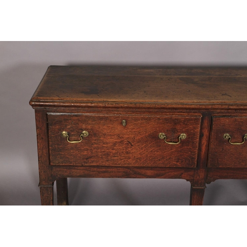 627 - AN 18TH CENTURY OAK DRESSER, the planked top with moulded edge, above three deep drawers with brass ... 