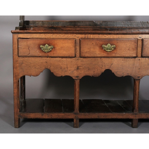 628 - A 19TH CENTURY DRESSER AND RACK, having a moulded cornice above a scalloped frieze, the open back wi... 