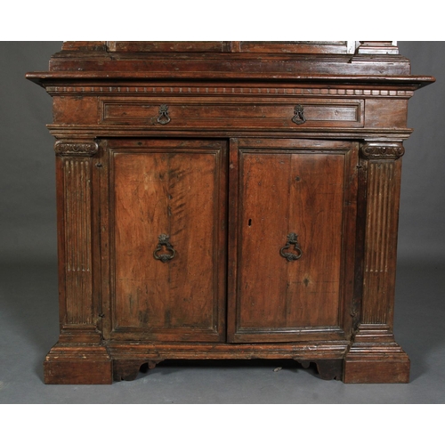 632 - AN ITALIAN WALNUT CUPBOARD, having a flared and dentil cornice above a deep frieze and two iron gril... 